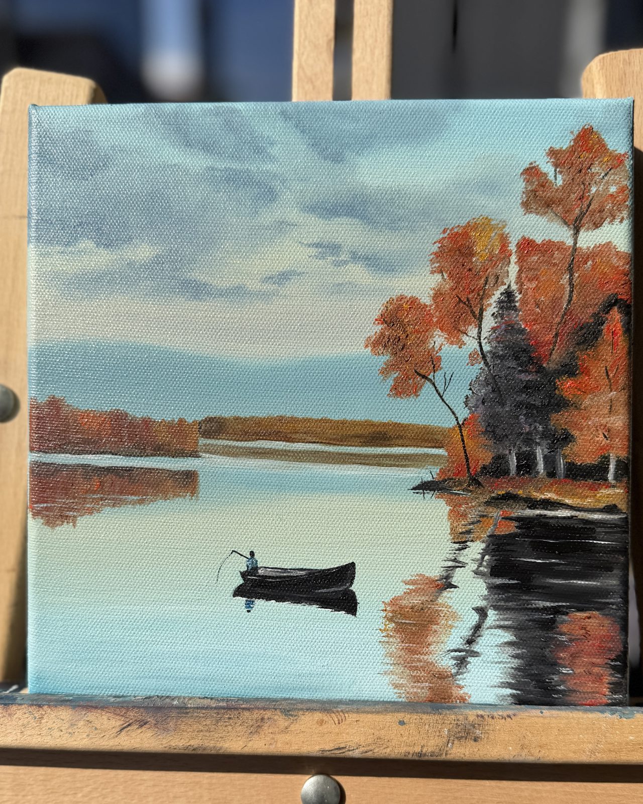 Rowboat on an Autumn Lake Mini Landscape Oil Painting — A lone fisherman in a rowboat on a calm lake framed by red-orange fall trees